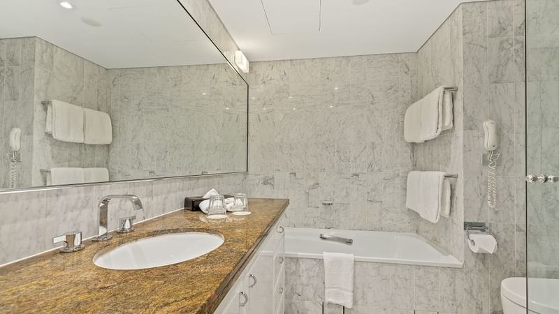 Bathroom with mirror & tub at The Sebel Quay West Suites Sydney