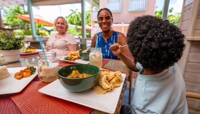 Family enjoying a delicious curry meal with flatbread at Hott Pott Restaurant dining table at Worthing Court Apartment