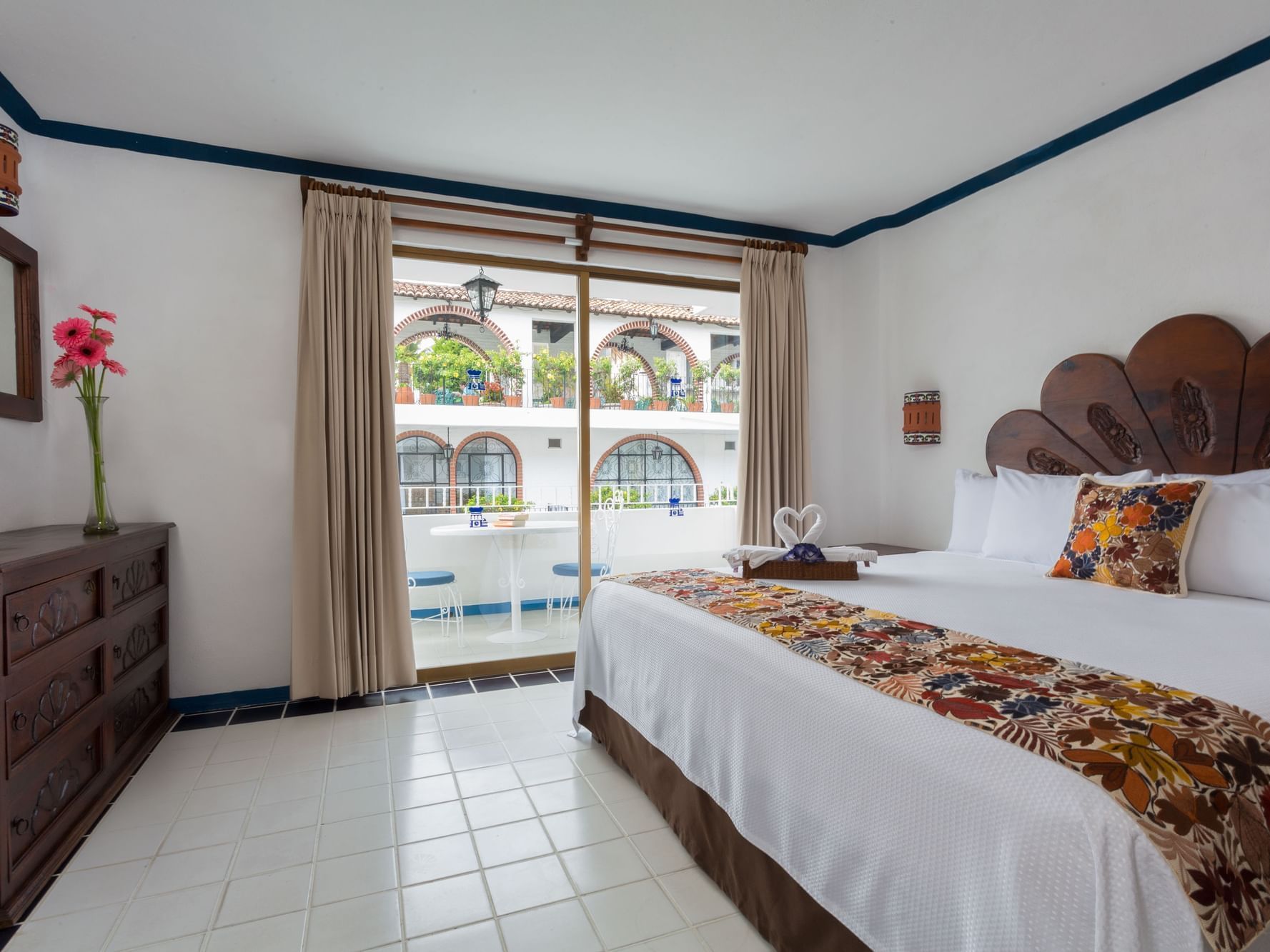 room with king bed, wooden dresser and large sliding glass door