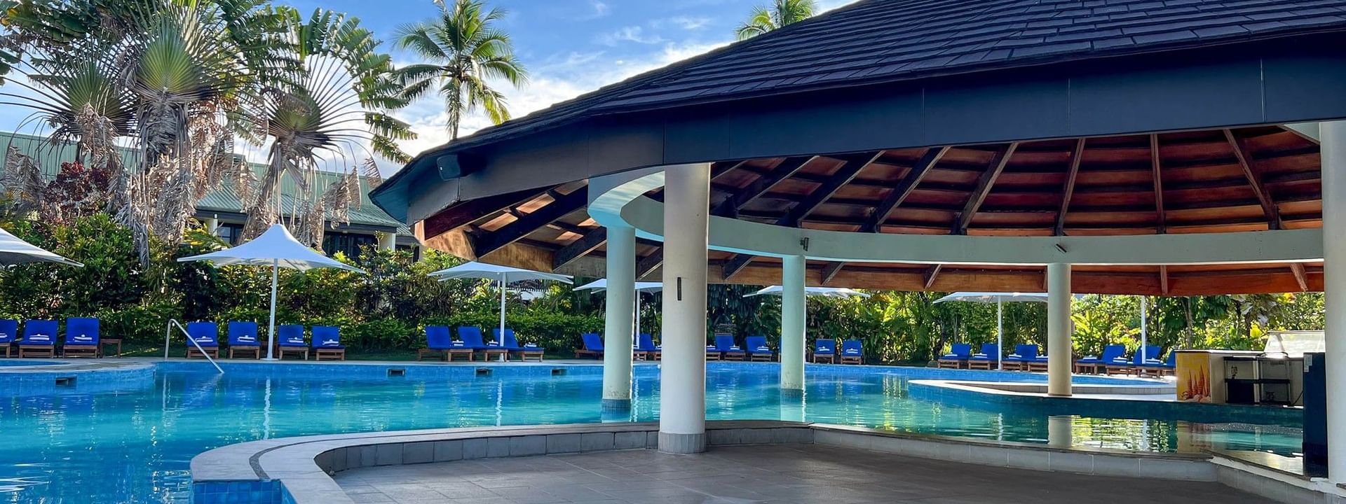 Swimming pool with blue water and cabanas at The Naviti Resort in Korolevu, Fiji