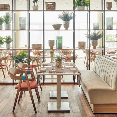 Elegante ristorante Artigiani con tavoli, sedie e piante al Falkensteiner Hotel & Spa Jesolo, Lido di Jesolo.