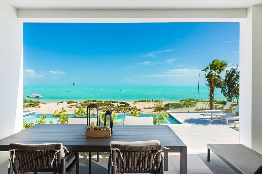 Beach House first-floor dining area at H2O life.style.resort, opening onto the pool deck and the turquoise water of Long Bay Beach