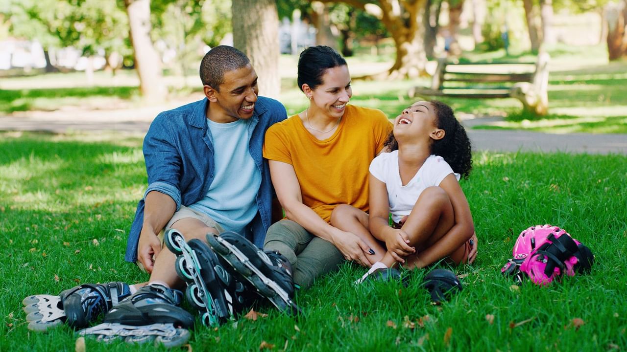 A family of three sitting at a park
