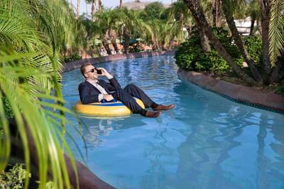 Business man in lazy river on cell phone