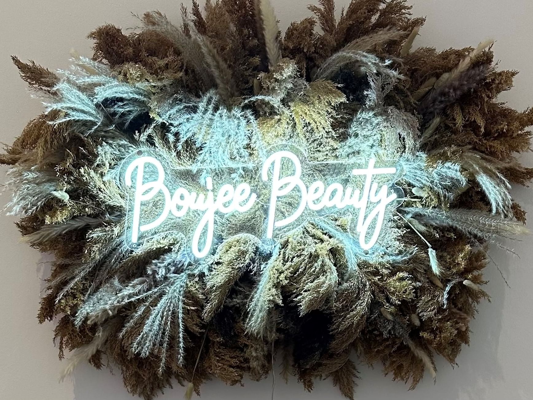A neon sign of Boujee Beauty hung on a wall near Retro Suites Hotel