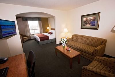 TV lounge area with bedroom in King Suite at Service Plus Inns & Suites Drayton Valley