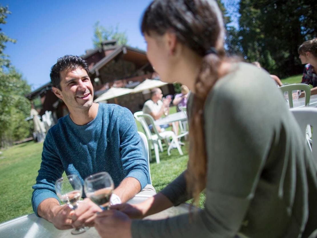 Two people talking at a table on Big Pine Lawn