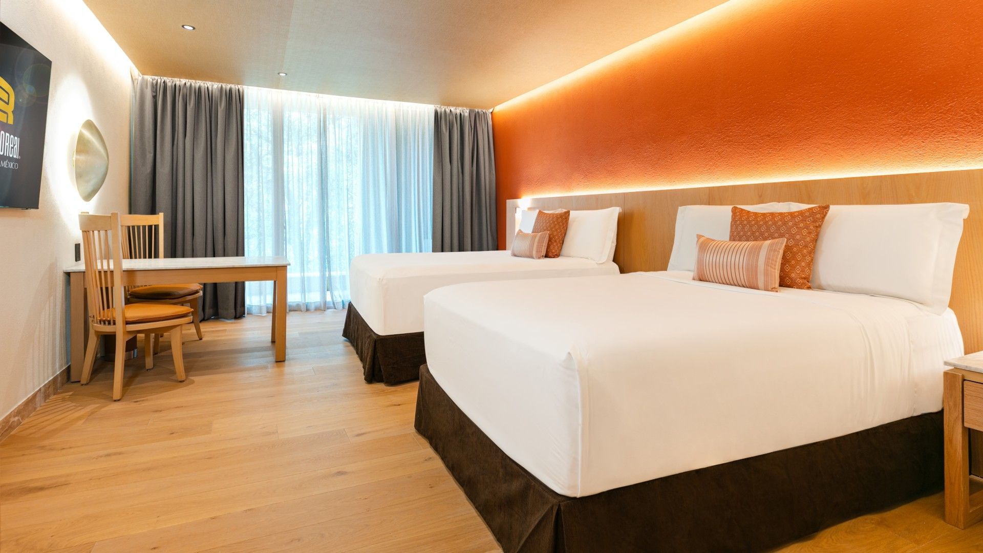 2 Double Deluxe Plus room featuring bright orange walls and a dining table by the window at Camino Real Polanco Mexico