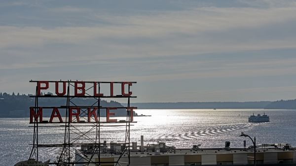 View of Public Market sign over water with a ferry in the distance near Warwick Seattle