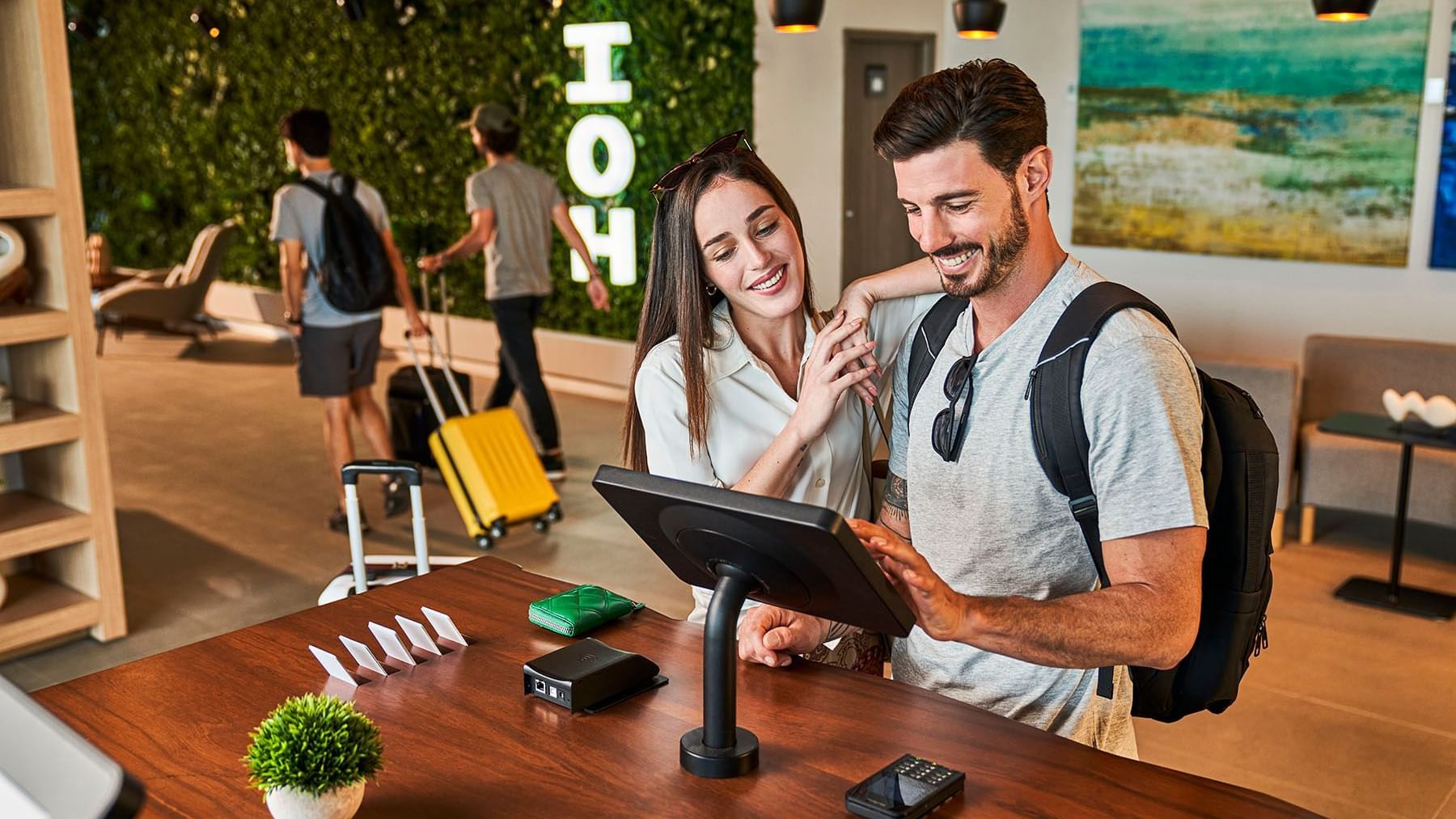 Couple checking in by the digital check-in desk at IOH Hotels