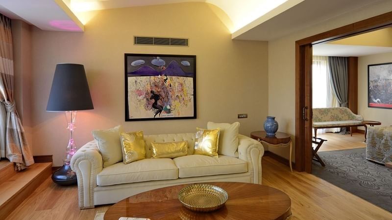 Warwick Suite with Terrace features Cream sofa and gold pillows by an oval wooden table at Warwick Ankara