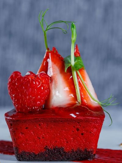 Postre gourmet cubierto con fresas, frambuesas y brotes verdes en el Sunset Plaza Beach Resort, uno de los mejores hoteles con vistas a la playa en Puerto Vallarta
