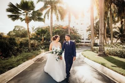 Bride & Groom walking down a path at Isla Verde Weddings