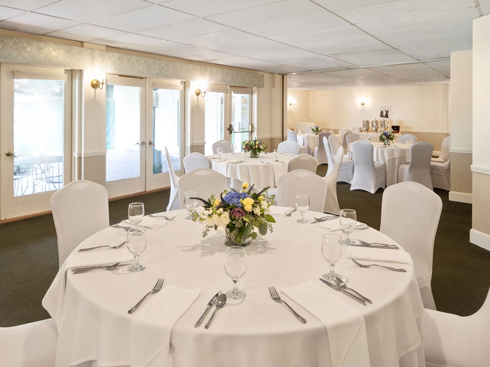 Banquet rounds arranged in the Merrymeeting Room at Harraseeket Inn by Ogunquit Collection