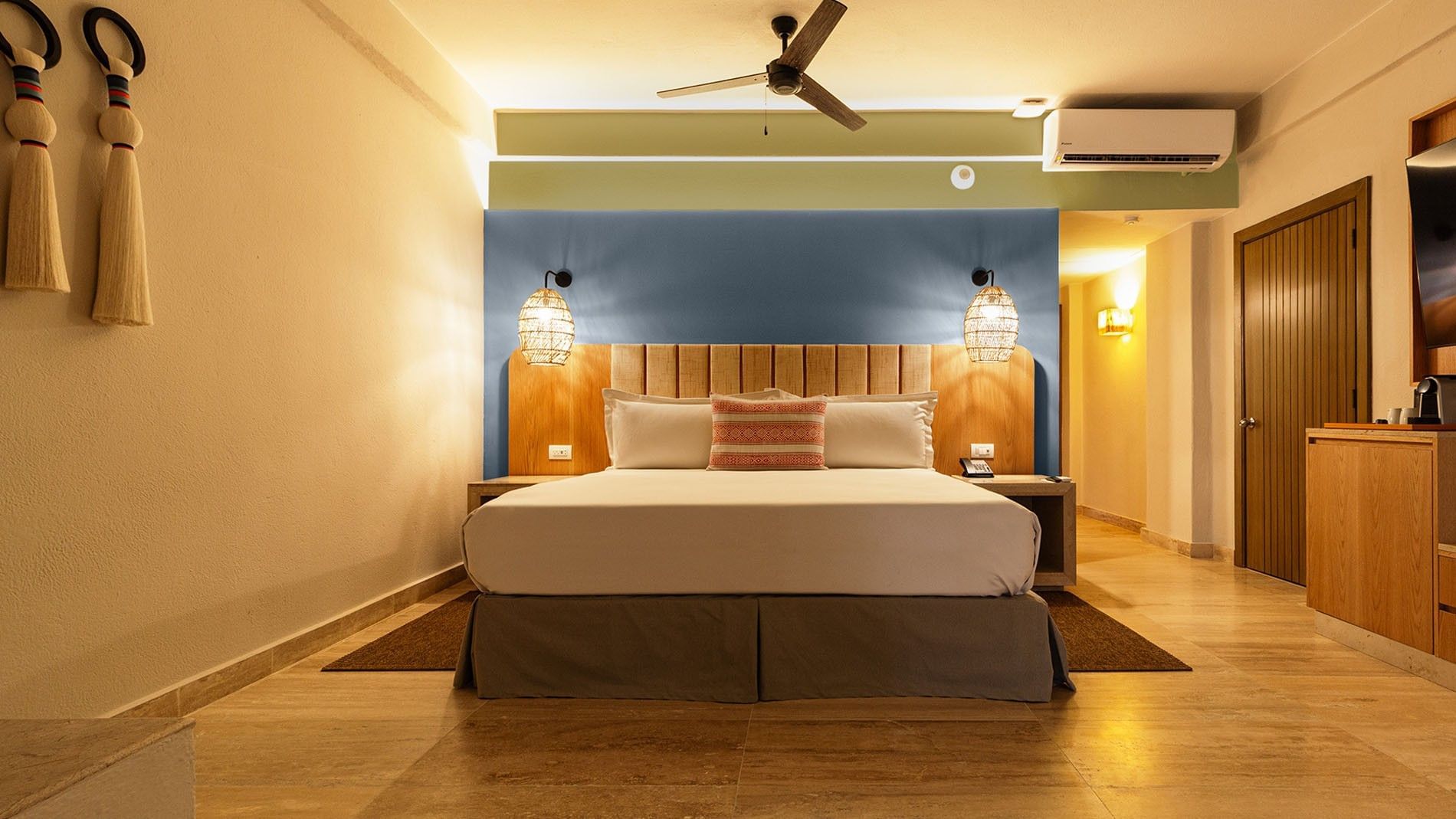 King Camino Real Club with blue accent wall, wood headboard, and warm ambient lighting at Camino Real Acapulco Diamante