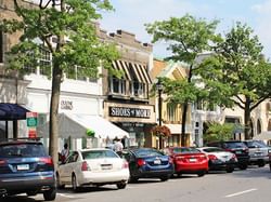 Shops and cars parked along Greenwich Avenue near J House Greenwich