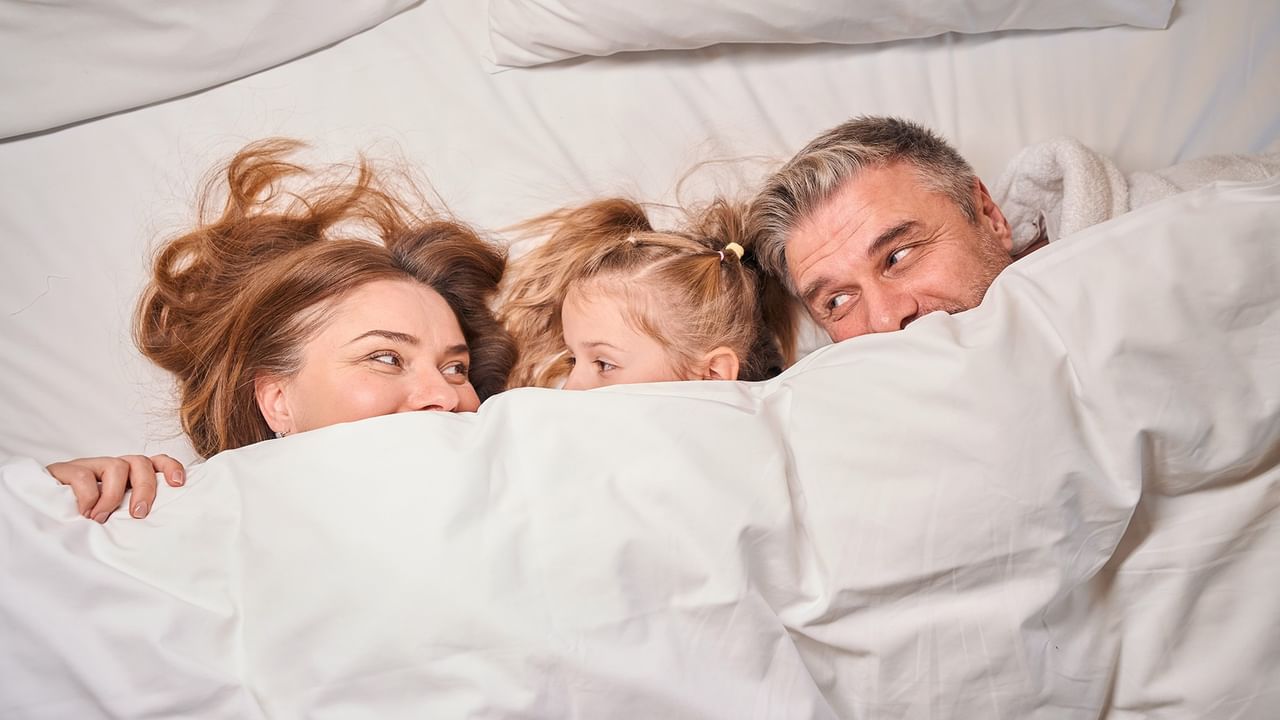 family cuddling in bed