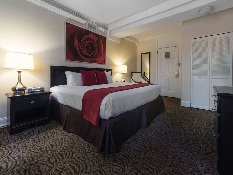 King bed in a room with a large rose painting at Artmore Hotel