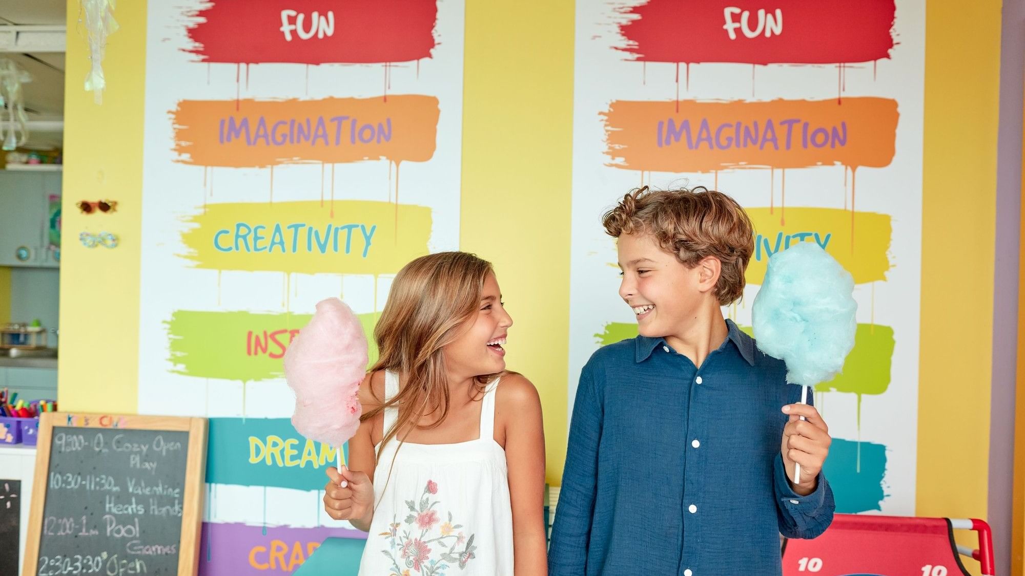 Children laughing and enjoying cotton candy at our Kids' Club.