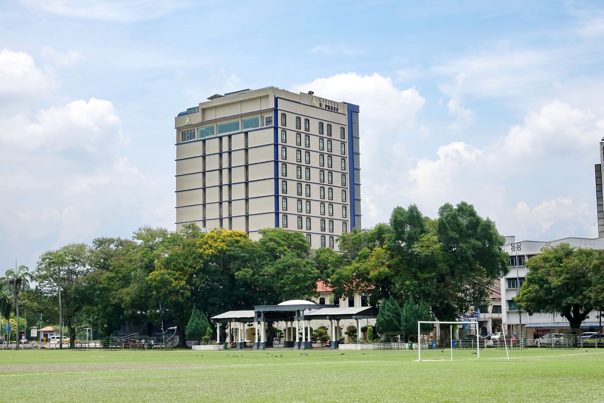 Exterior view of Cititel Express Ipoh with a green soccer field and trees
