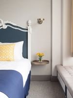 Deluxe Queen Room features Bed by a floating metal nightstand under a brass wall sconce at Warwick San Francisco