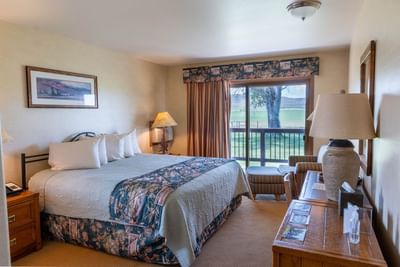 Cozy seating area and work desk facing the bed with views of surrounding greenery in The Hunting Lodge at The Ranch at UCross