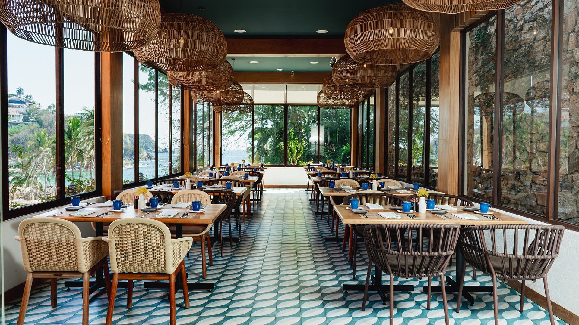 Bright, airy dining area with large windows showcasing a tropical view in Chez Binni at Camino Real Zaashila Huatulco