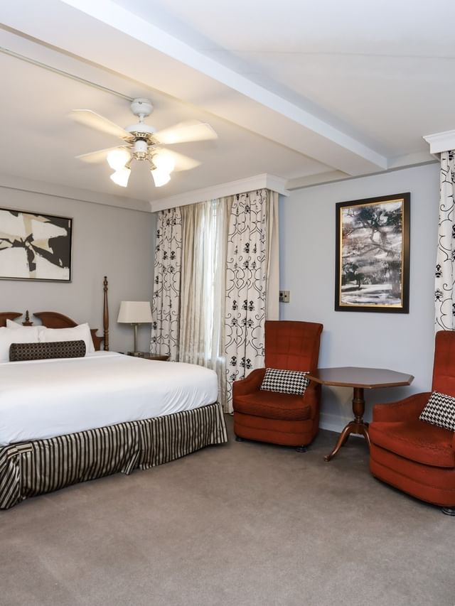 Junior Suite featuring two red lounge chairs and a white sofa by the window at Arlington Resort Hotel & Spa