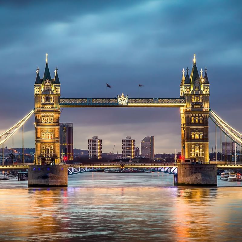 The illuminated Tower Bridge spans the River Thames, showcasing locations near Warwick Hotels and Resorts