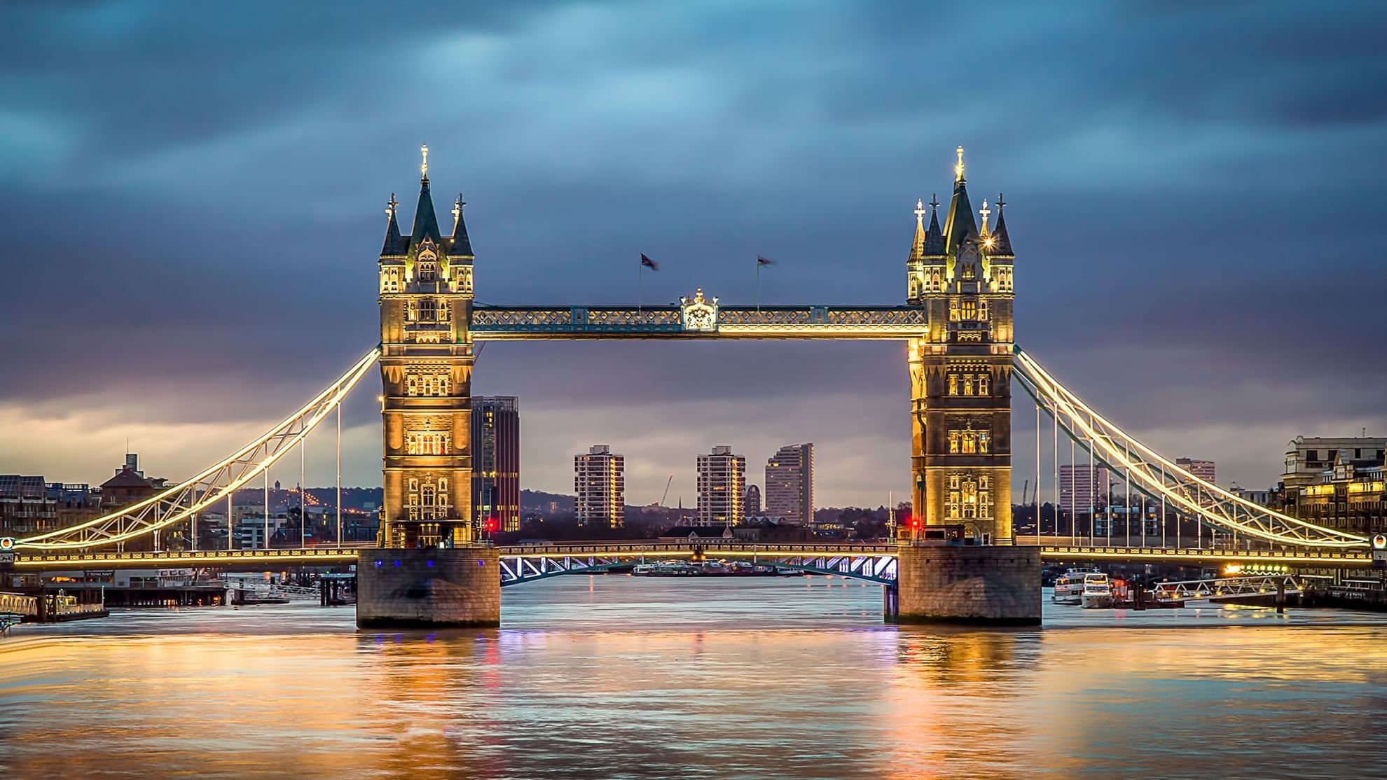 The illuminated Tower Bridge spans the River Thames, showcasing locations near Warwick Hotels and Resorts