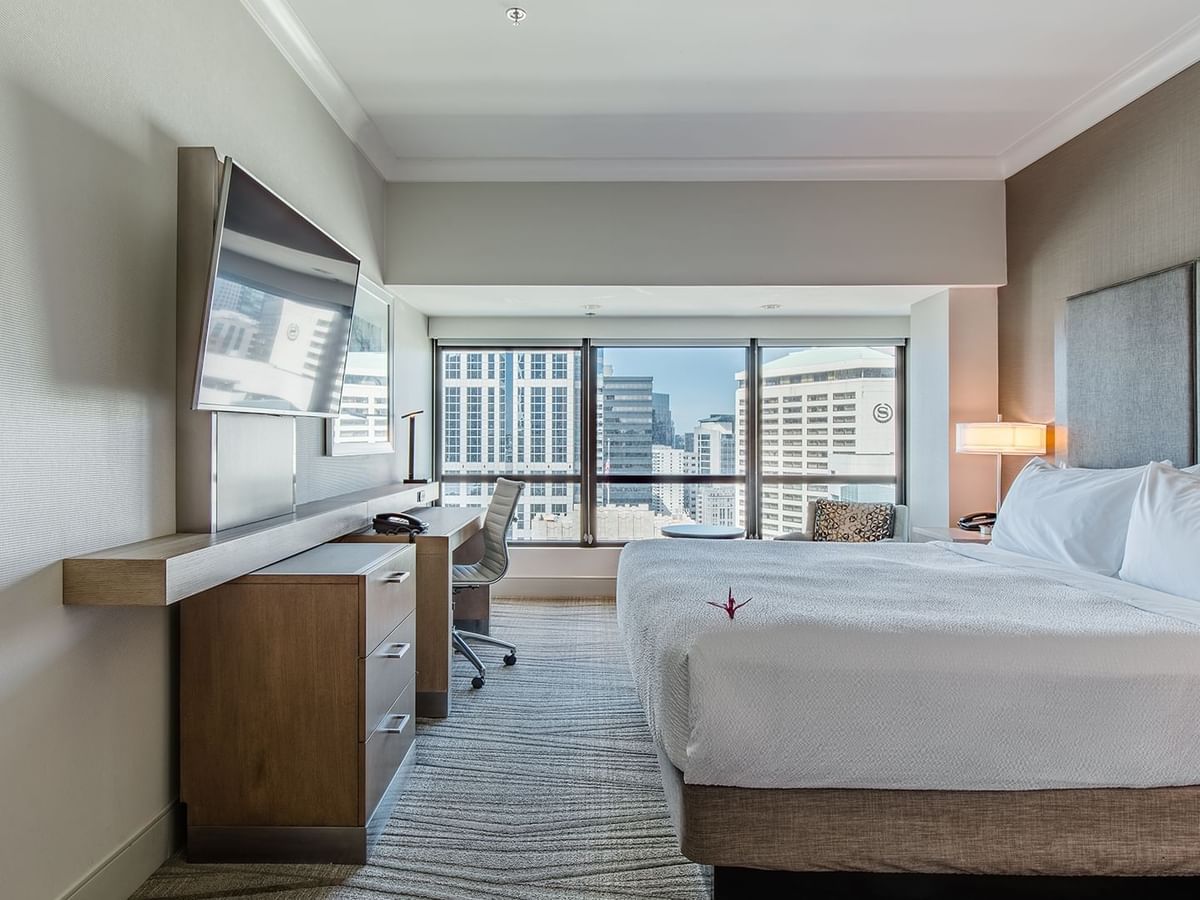 Hotel guestroom with king bed, TV and desk