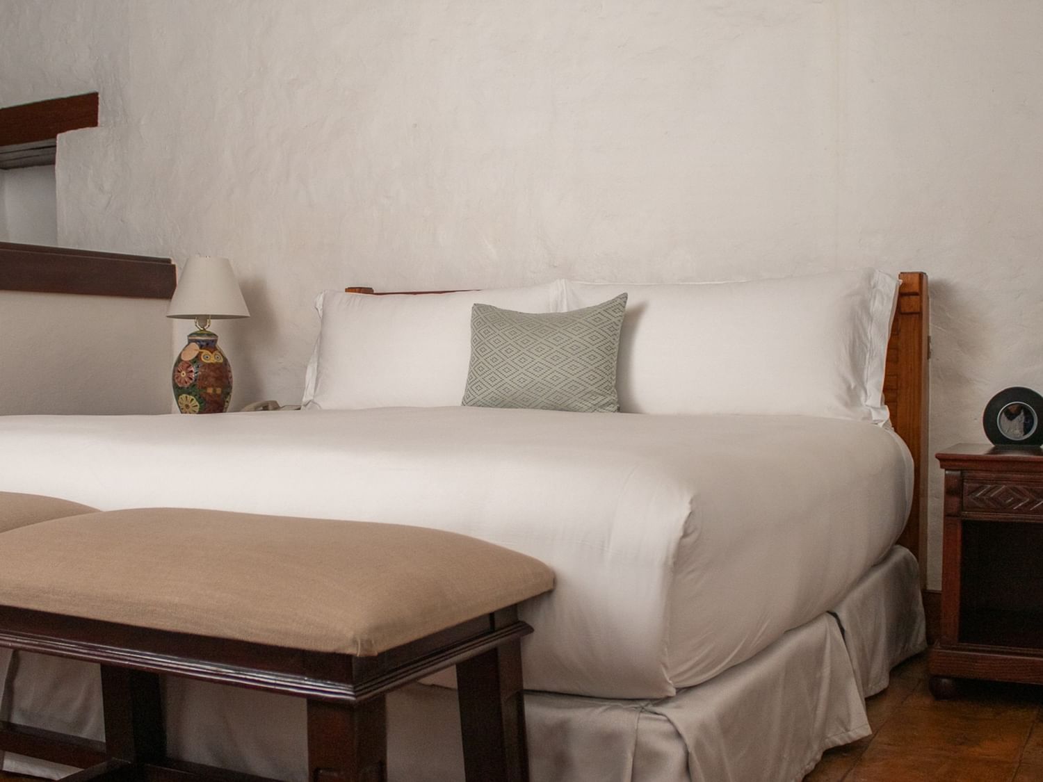 Cama grande con almohadas y cojines en la Suite Gobernador King en Quinta Real Oaxaca