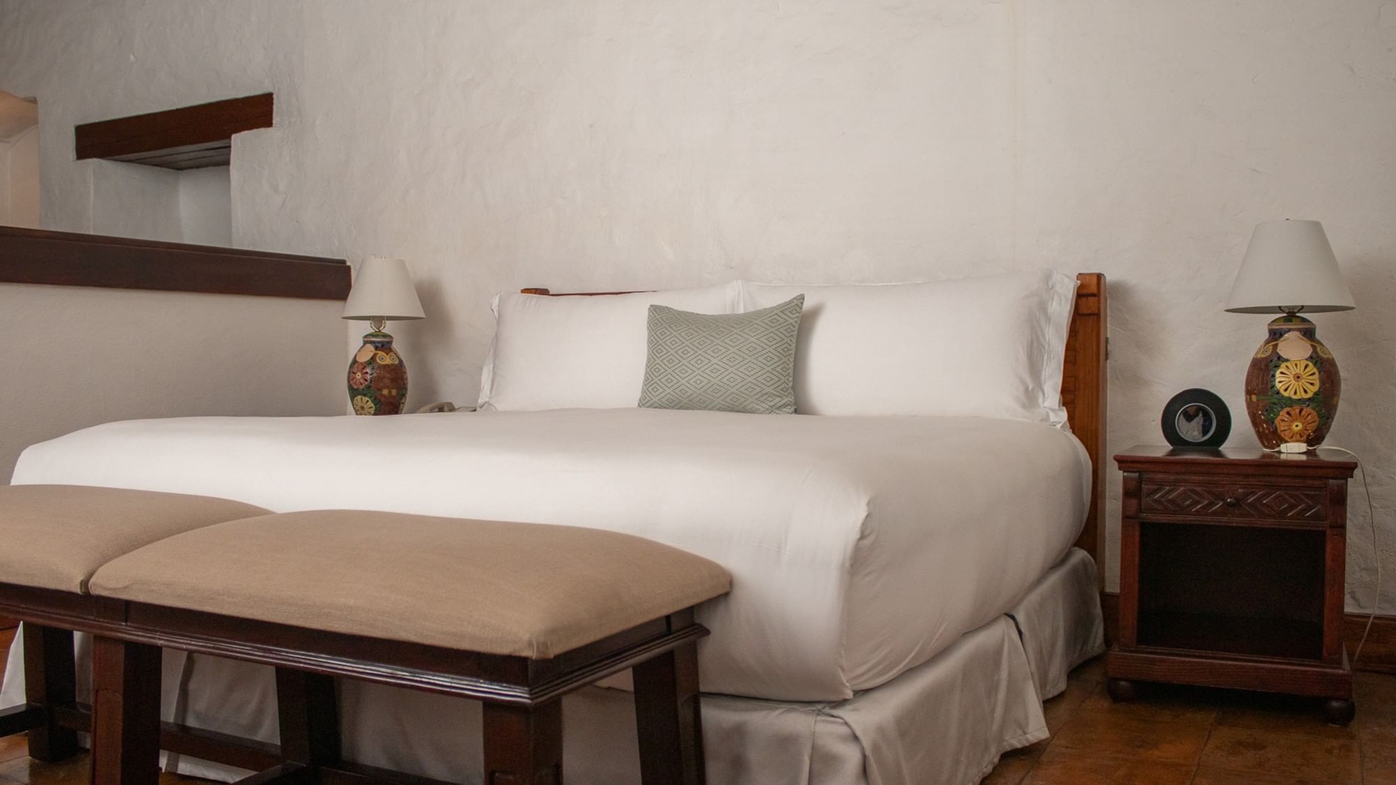 Cama grande con almohadas y cojines en la Suite Gobernador King en Quinta Real Oaxaca