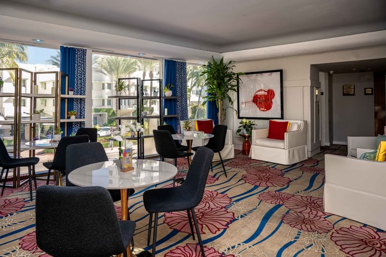 A hotel lobby with seating areas and a view of the outside.