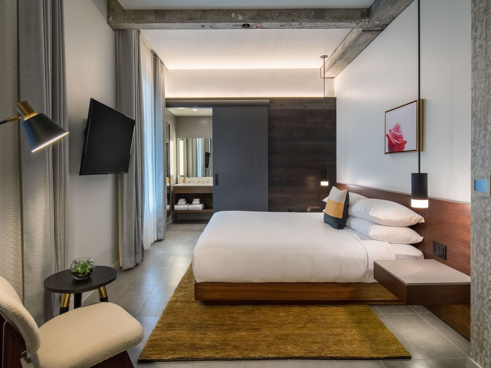 Hi-Lo hotel room with bed and television mounted on wall