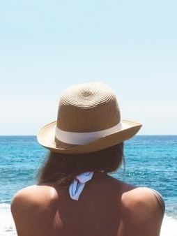 Lady overlooking the Sea from shore near Oceania Hotels Group