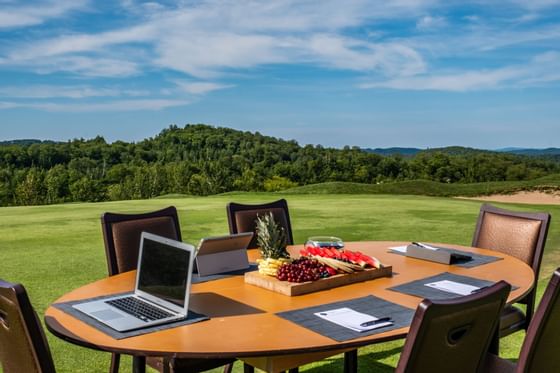 Laptop & fruits on a table outdoors at Mont Gabriel Resort