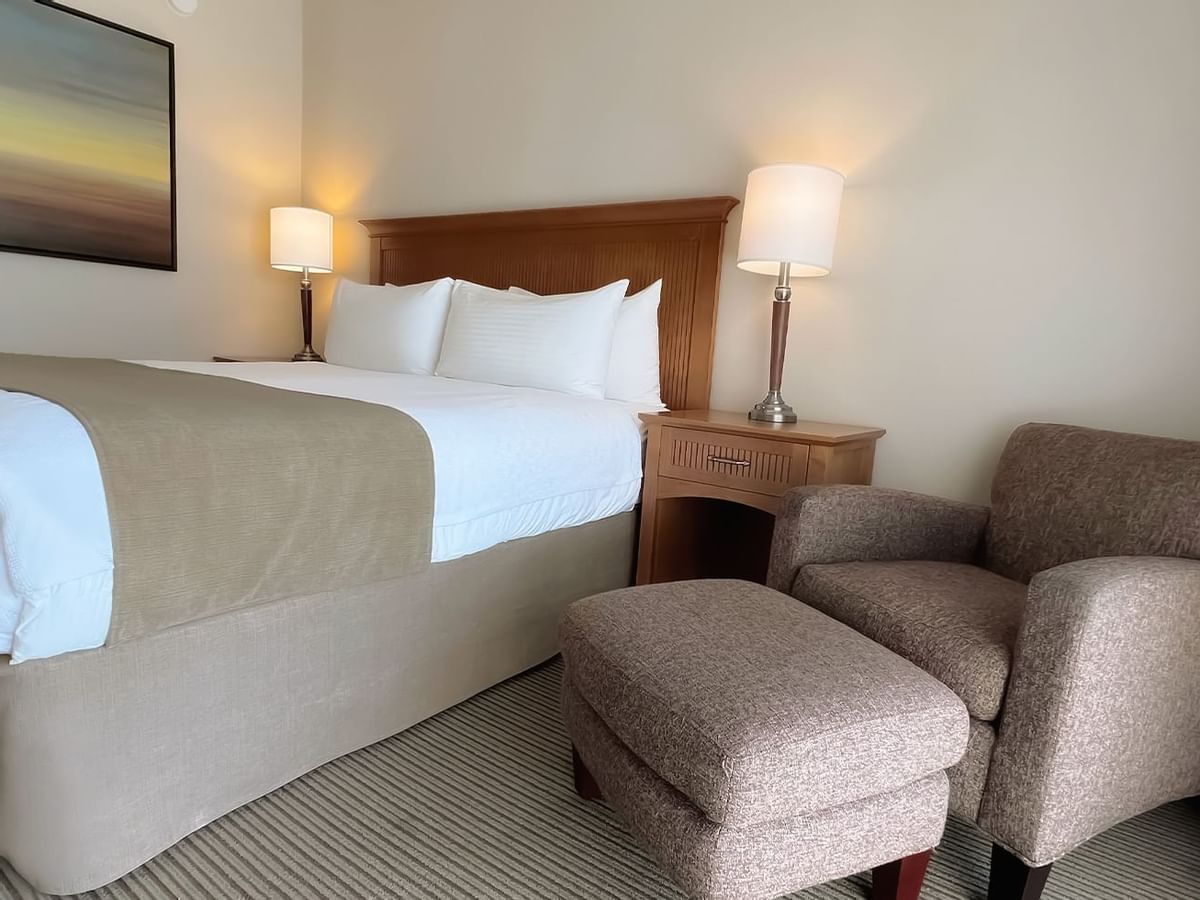 Guest room with king bed, lamps and chair
