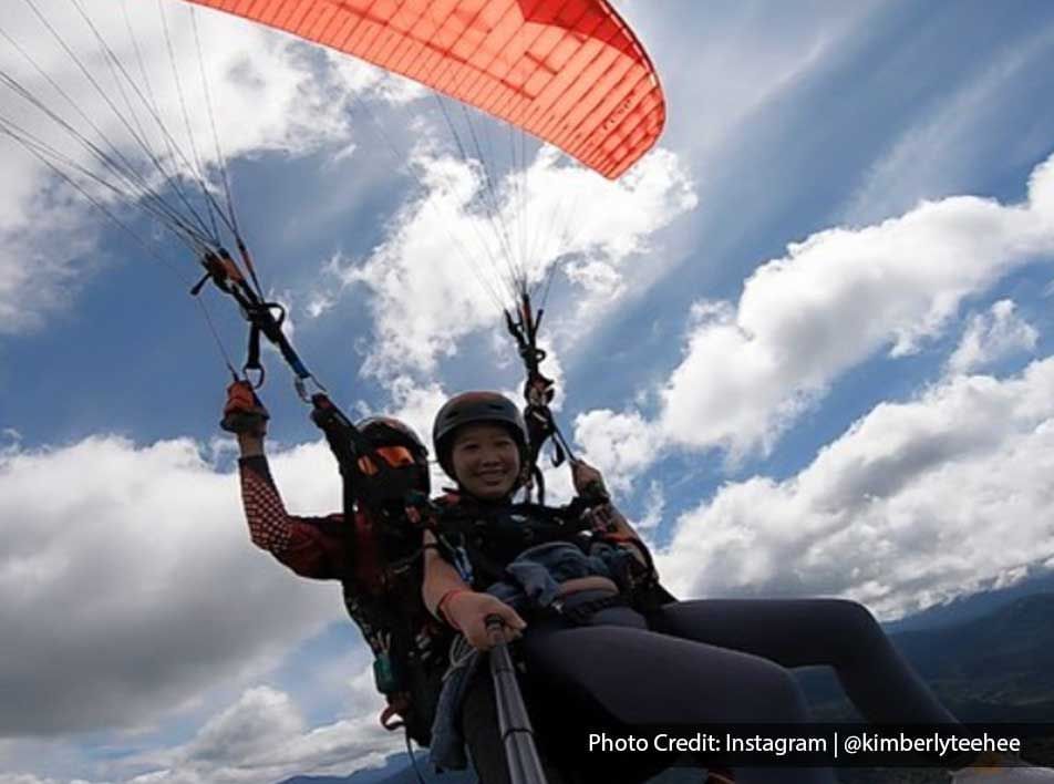 A woman was taking a selfie while tandem paragliding in KKB Paragliding Park - Lexis Suites Penang