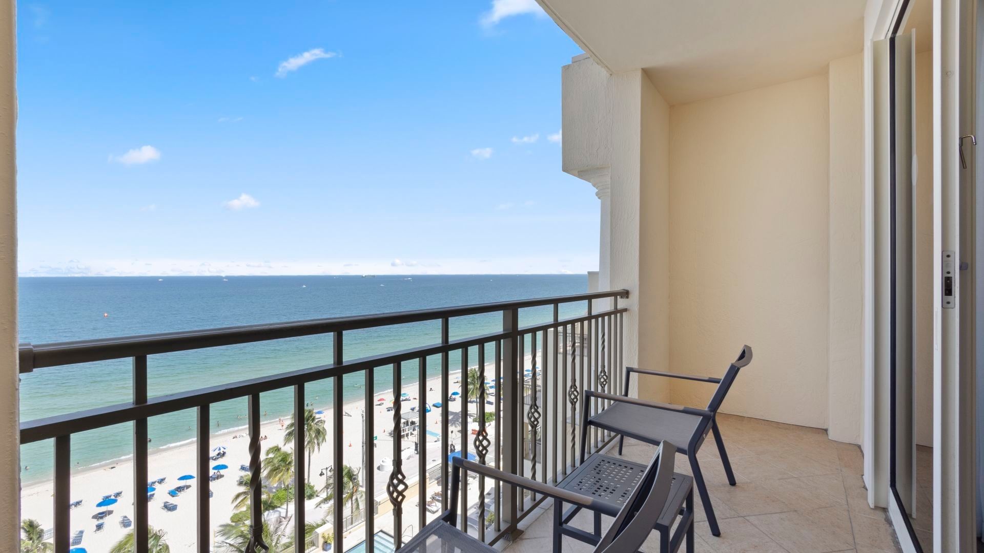 A balcony with a view of the beach and sea