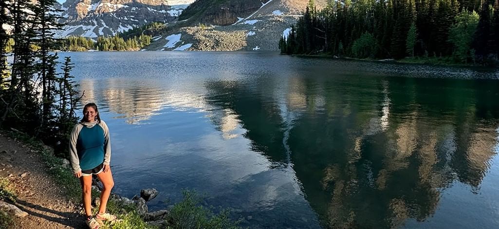 A person stands by a picturesque lake in Banff National Park.