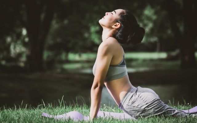 Women on a yoga retreat practicing yoga poses outside