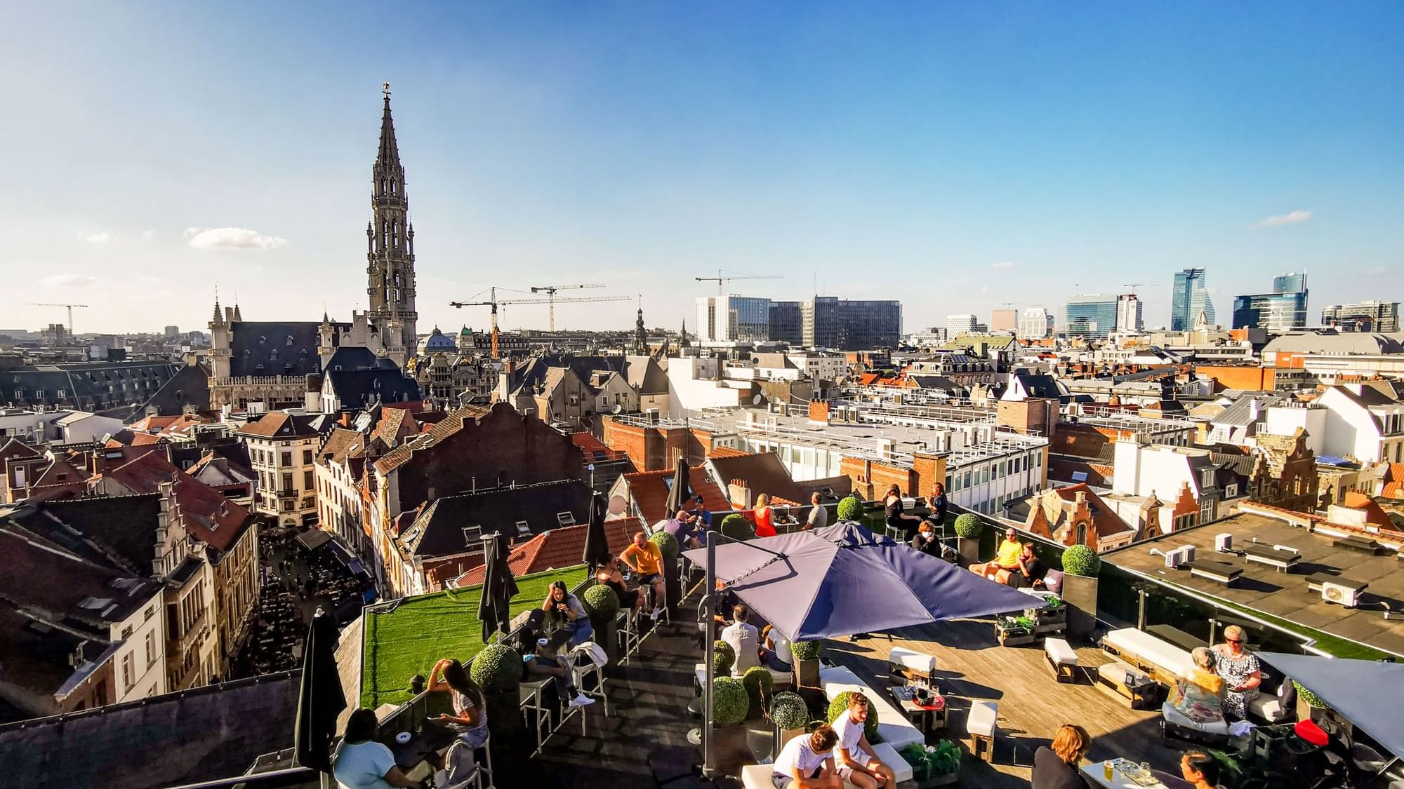 Secret Rooftop Bar with people dining overlooking a cityscape at Warwick Brussels