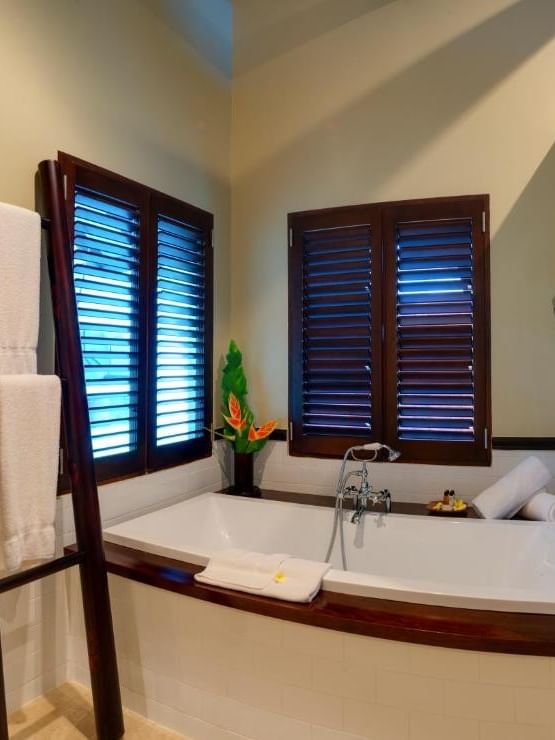Shefa Pool Villa bathroom with large tub and window shutters at Warwick Le Lagon - Vanuatu, Efate.