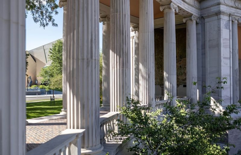 Tall marble columns by a stone path under a clear sky near a grassy lawn at Warwick Denver