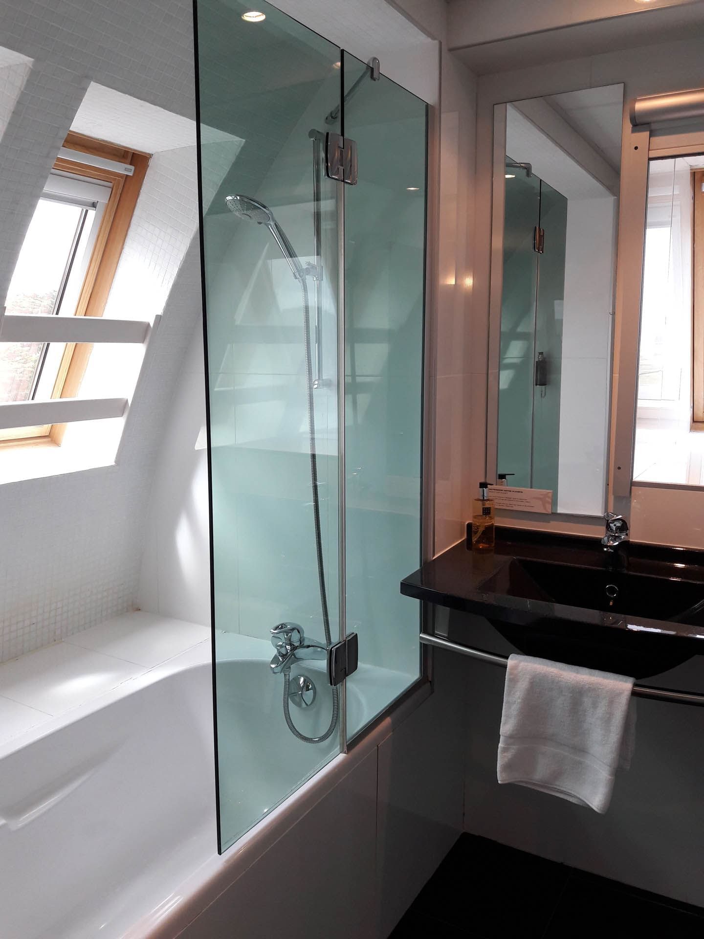 Salle de bain avec douche, miroir et lavabo à l'Escale Oceania Pornichet