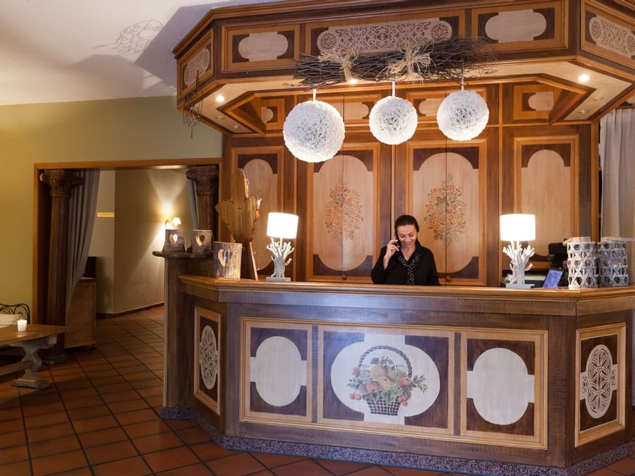 A receptionist at the reception desk in Le Verger des Chateaux