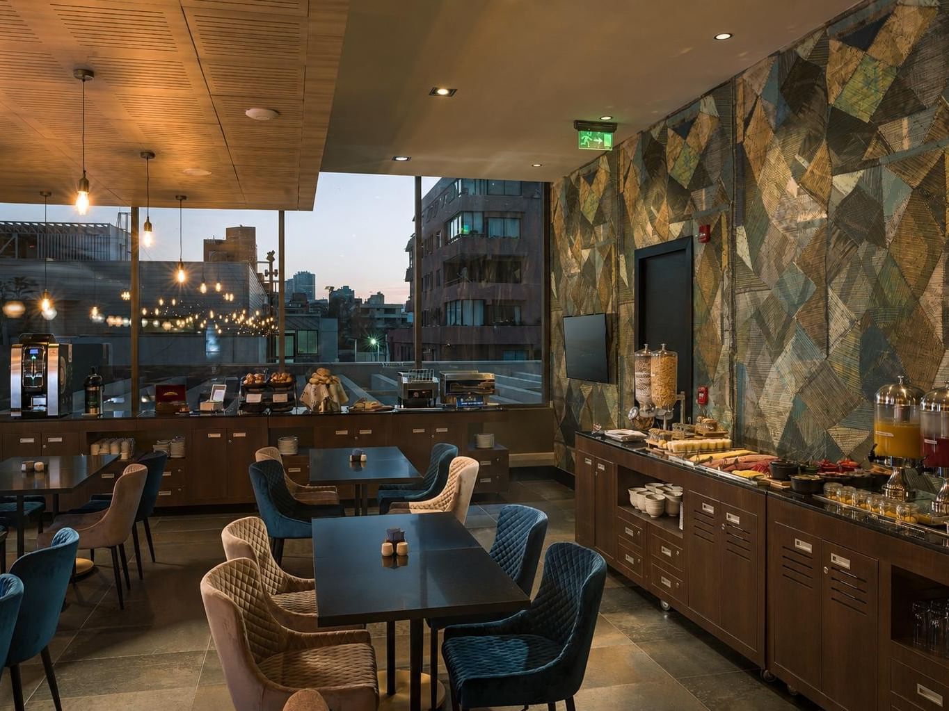 Comedor de Veranda Restaurant con mesas y buffet de desayuno frente a edificios de la ciudad en Veranda Hotel
