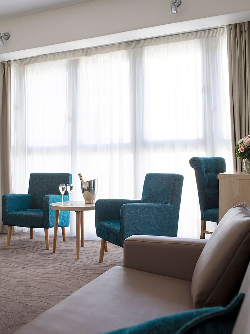 Deux fauteuils confortables et une table basse sur laquelle trône une bouteille de champagne dans la suite du Splendid Hotel & Spa à Nice