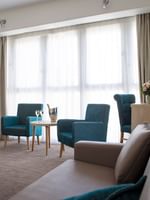 Deux fauteuils confortables et une table basse sur laquelle trône une bouteille de champagne dans la suite du Splendid Hotel & Spa à Nice